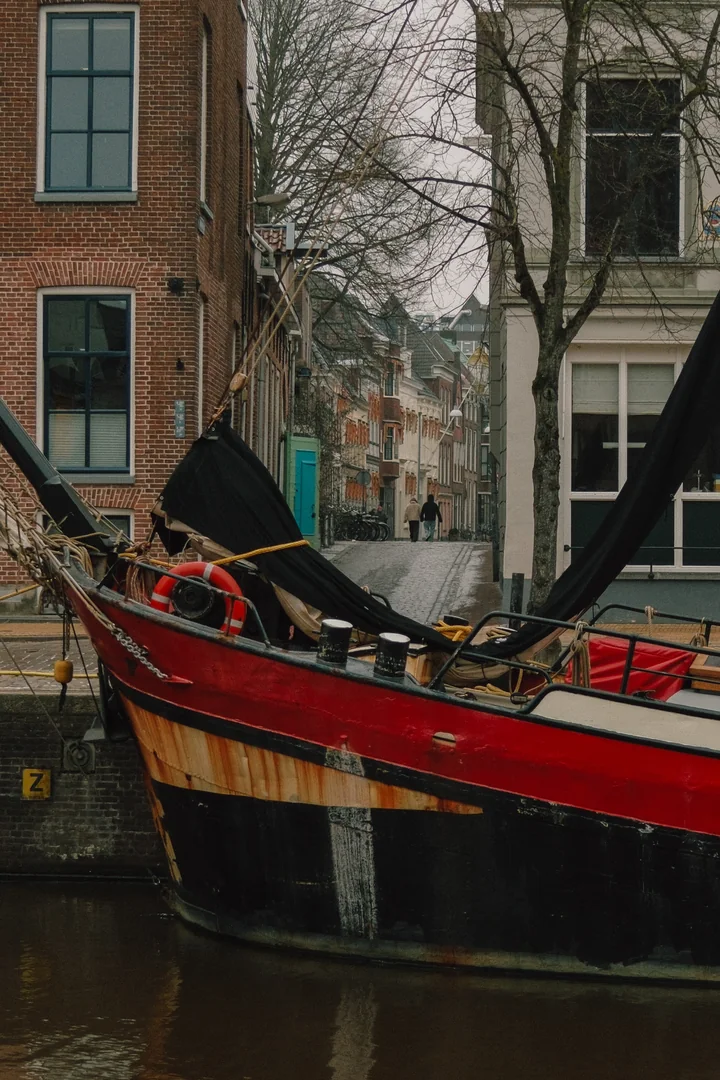 Rode woonboot langs een Groningse straat